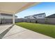 Covered patio in a spacious backyard featuring lush artificial grass, a block fence, and young trees at 10155 E Toledo Ave, Mesa, AZ 85212