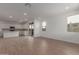 Bright, open-concept living area with wood-look tile flooring, leading to a modern kitchen with white cabinets at 15595 S 181St Dr, Goodyear, AZ 85338