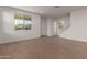 Open living space with wood-look tile flooring and bright natural light, flowing into a kitchen and staircase at 15595 S 181St Dr, Goodyear, AZ 85338