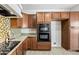 Kitchen boasting a double oven, granite counters, and dark wood cabinets at 1724 S Rockwell St, Gilbert, AZ 85295