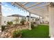 Landscaped backyard with a pergola-covered patio and artificial turf at 27078 W Yukon Dr, Buckeye, AZ 85396