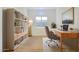 Bright home office featuring a wooden desk, white shelving, and a comfortable chair at 17917 W Amberwood Dr, Goodyear, AZ 85338