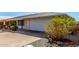 House exterior showcasing a garage and mature landscaping at 9409 W Glen Oaks N Cir, Sun City, AZ 85351