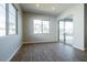Bright bedroom with wood-look tile flooring, two windows, and a sliding glass door to the backyard at 1284 E Coconino Way, Gilbert, AZ 85298