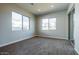 Bright bedroom with wood-look tile flooring, two windows, and a sliding glass door to the backyard at 1284 E Coconino Way, Gilbert, AZ 85298