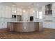 Close up of large kitchen island with a white countertop, wood-look base, and modern lighting fixtures at 1284 E Coconino Way, Gilbert, AZ 85298