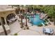 An elegant outdoor kitchen and covered seating area complement the sprawling pool with rock waterfall and slide at 2494 E Cloud Dr, Chandler, AZ 85249