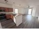 Open floor plan featuring kitchen, stainless appliances, breakfast bar, and modern gray wood flooring at 11560 W Kinderman Dr, Avondale, AZ 85323