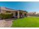 Backyard featuring lush grass, covered patio, and well-maintained landscaping at 22364 N 67Th Dr, Glendale, AZ 85310