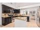 Modern kitchen with stainless steel appliances, granite countertops, dark cabinets, and a functional island at 22364 N 67Th Dr, Glendale, AZ 85310