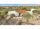 Stunning aerial view of a desert home with a red tile roof surrounded by lush greenery and desert landscape at 7928 E Parkview Ln, Scottsdale, AZ 85255