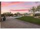 Desert backyard featuring a pool, lush grass, and paver patio under a vibrant evening sky at 7928 E Parkview Ln, Scottsdale, AZ 85255