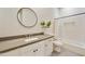 Bathroom with a dark-gray countertop, white cabinetry and decorative mirror at 7928 E Parkview Ln, Scottsdale, AZ 85255