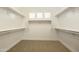 Spacious walk-in closet featuring built-in shelving and neutral carpeting at 7928 E Parkview Ln, Scottsdale, AZ 85255