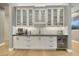 Wet bar featuring stainless steel appliances, custom cabinets, stone countertops, and bar seating at 7928 E Parkview Ln, Scottsdale, AZ 85255