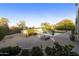 Landscaped backyard boasts a sparkling pool, stone patio, mature trees, and desert vegetation for tranquil outdoor living at 7928 E Parkview Ln, Scottsdale, AZ 85255