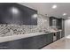 Modern wet bar with dark cabinetry and a herringbone backsplash at 9027 N 82Nd St, Scottsdale, AZ 85258