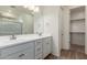 Bathroom featuring double sinks, a large mirror, and a shower and a door to the closet at 18197 W Cielo Grande Ave, Surprise, AZ 85387