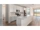 Bright, white kitchen featuring stainless steel appliances, ample counter space, and wood-look tile flooring at 18197 W Cielo Grande Ave, Surprise, AZ 85387