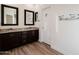 Bathroom with granite countertops, dark wood cabinets, and large mirrors at 41515 N Chase Oaks Way, Anthem, AZ 85086