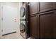 Laundry room with stacked washer/dryer and ample cabinet storage at 41515 N Chase Oaks Way, Anthem, AZ 85086