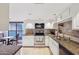 Well-lit kitchen with granite counters, white cabinetry, tile backsplash, and stainless steel appliances at 5122 N 31St Way # 244, Phoenix, AZ 85016