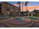 Community pool area features a spa, pool, and lounge chairs for relaxing in the sun at dusk at 5122 N 31St Way # 244, Phoenix, AZ 85016