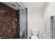 Bathroom with glass enclosed walk-in shower featuring marble tile surround and built-in shelves at 5122 N 31St Way # 244, Phoenix, AZ 85016