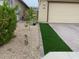 Low maintenance yard with gravel and artificial turf next to a home's garage and driveway at 5819 N 88Th Ln, Glendale, AZ 85305