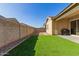 Landscaped backyard with artificial turf and block wall at 4287 E Clifton Ave, Gilbert, AZ 85295