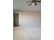 The spacious living room features plush neutral carpeting, a ceiling fan, and an open doorway at 11110 W Peace Ct, Sun City, AZ 85351