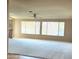 Bright living room with a ceiling fan, large windows providing natural light, and plush neutral carpeting at 11110 W Peace Ct, Sun City, AZ 85351