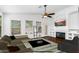 Cozy living room with a fireplace, ceiling fan, and large windows for ample natural light at 17006 N 44Th Pl, Phoenix, AZ 85032