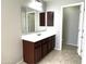 Bathroom with dark brown vanity and tiled floor at 17323 W Woodlands Ave, Goodyear, AZ 85338