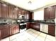 Spacious kitchen featuring dark wood cabinets and stainless steel appliances at 17323 W Woodlands Ave, Goodyear, AZ 85338