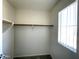 Well-lit walk-in closet with wood shelving at 17323 W Woodlands Ave, Goodyear, AZ 85338