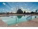 Community swimming pool surrounded by lush landscaping and clear blue skies in the background at 17200 W Bell Rd # 667, Surprise, AZ 85374