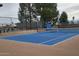 Well-maintained blue tennis court with green fencing, providing a great recreational amenity at 17200 W Bell Rd # 667, Surprise, AZ 85374