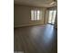 Bright living room featuring hardwood floors, neutral paint, plantation shutters, and a sliding glass door to the patio at 18774 N 95Th Ave, Peoria, AZ 85382