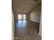 Bright living room with a vaulted ceiling, wood floors, ceiling fan, and sliding doors to the outside at 18774 N 95Th Ave, Peoria, AZ 85382