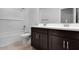 Modern bathroom with double sinks, dark cabinetry, and tiled shower/tub at 4107 E Ghost Flower Ln, San Tan Valley, AZ 85140