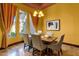 Bright dining room with neutral paint features travertine floors, a stylish chandelier, and backyard views at 4301 E Taurus Pl, Chandler, AZ 85249