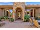 Stunning stone entryway features an arched doorway and decorative iron door, adding curb appeal to the home at 4301 E Taurus Pl, Chandler, AZ 85249