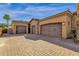 Three-car garage featuring dark doors and desert landscaping at 4301 E Taurus Pl, Chandler, AZ 85249