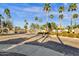 View of the Vasaro community entrance with automated gates, stone walls, and mature landscaping with desert trees at 4301 E Taurus Pl, Chandler, AZ 85249