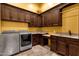 Functional laundry room with granite countertops, custom cabinets, a sink, and stainless steel washer and dryer at 4301 E Taurus Pl, Chandler, AZ 85249