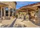 A covered outdoor kitchen and bar area complete with stone pillars and tile roofing at 4301 E Taurus Pl, Chandler, AZ 85249