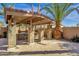 Outdoor kitchen under covered patio with stone pillars and a grill at 4301 E Taurus Pl, Chandler, AZ 85249