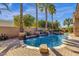 A private pool featuring waterfalls, palm trees, and a spacious stone patio for outdoor relaxation and entertaining at 4301 E Taurus Pl, Chandler, AZ 85249