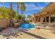 A view of the backyard featuring the pool with lush landscaping, waterfalls, and home at 4301 E Taurus Pl, Chandler, AZ 85249